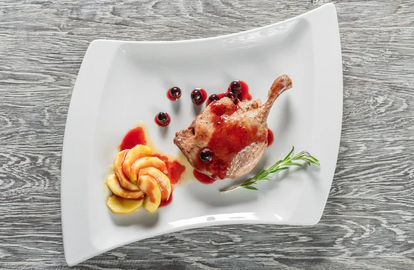 Beyaz tabakta ördek bacak confit sağlıklı bir kahvaltı ile karamelize elma
