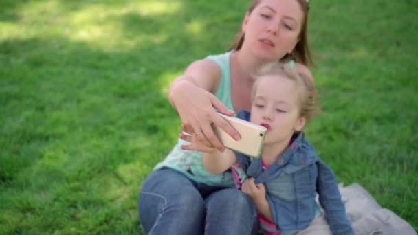 Mamá con una hija pequeña hacer selfie . — Vídeos de Stock