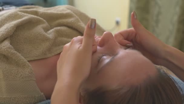 Massagista fazendo massagem um rosto de mulher . — Vídeo de Stock