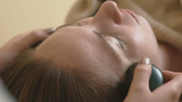 Jonge vrouw doet hot stone-massage-Wellness. — Stockvideo