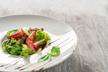 Yeşil salata, peynir ve çilek balzamik sos ile.