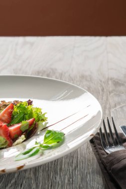 Yeşil salata, peynir ve çilek balzamik sos ile.