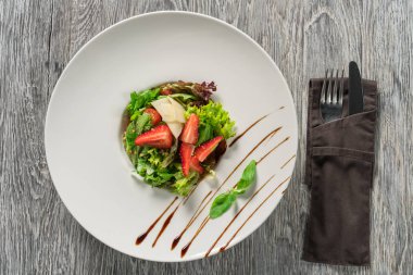 Yeşil salata, peynir ve çilek balzamik sos ile.