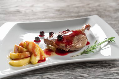Beyaz tabakta ördek bacak confit sağlıklı bir kahvaltı ile karamelize elma