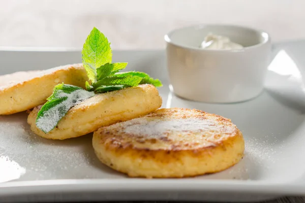 Cheese pancakes with sour cream — Stock Photo, Image