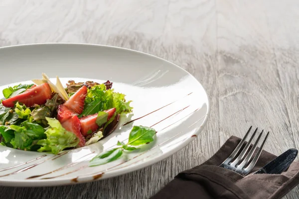 Yeşil salata, peynir ve çilek balzamik sos ile.