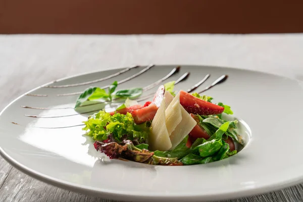 Yeşil salata, peynir ve çilek balzamik sos ile.