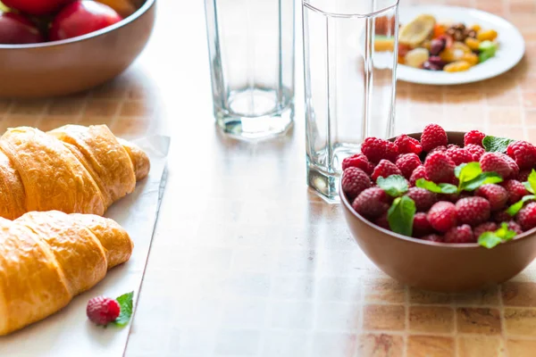 Croissants et framboises sur la table . — Photo