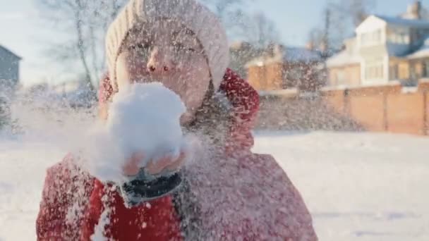 Девушка дует снегом руками . — стоковое видео