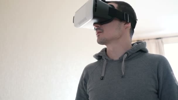 Mann trägt Virtual-Reality-Headset im Wohnzimmer.
