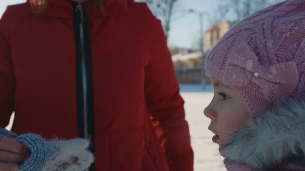 Mutter kleidet Tochter Fäustlinge. — Stockvideo