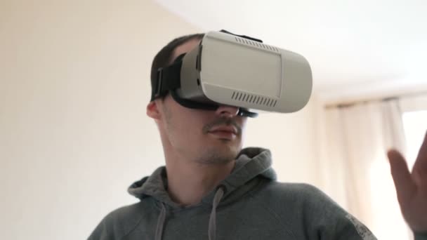 Mann trägt Virtual-Reality-Headset im Wohnzimmer. — Stockvideo