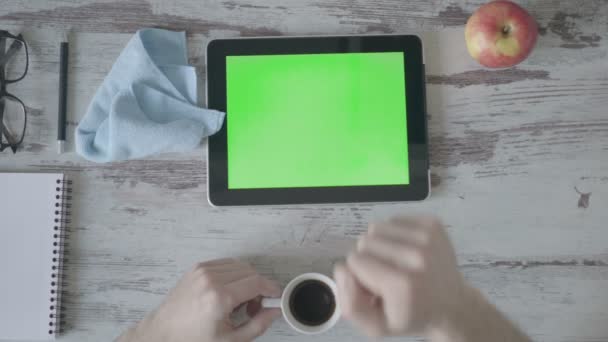 Бизнесмен с помощью планшетного компьютера работает из дома, пьет кофе — стоковое видео