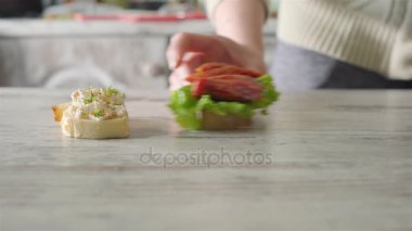 Kız masanın üzerinde farklı sandviç ortaya konuyor