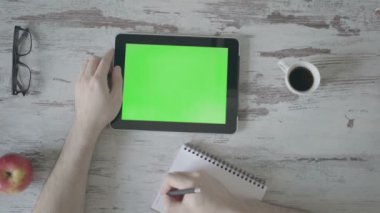 Erkek el yapmak notlar bir defter, sonraki bir tablet ile yeşil bir ekran olduğunu