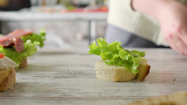 サラダの葉、広がり、チェリー トマトのサンドイッチを作る女性 — ストック動画