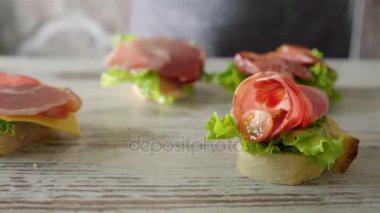 Salata yaprağı, yaymak, kiraz domates ile sandviç yapma kadın