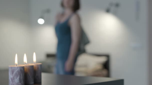 Κορίτσι στέκεται στο δωμάτιο με κεριά — Αρχείο Βίντεο