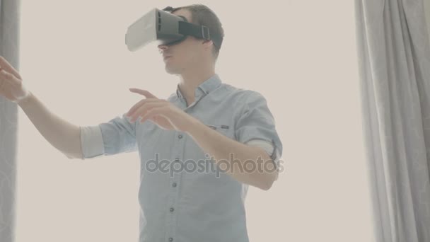 Hombre en una máscara de realidad virtual mira a su alrededor . — Vídeo de stock
