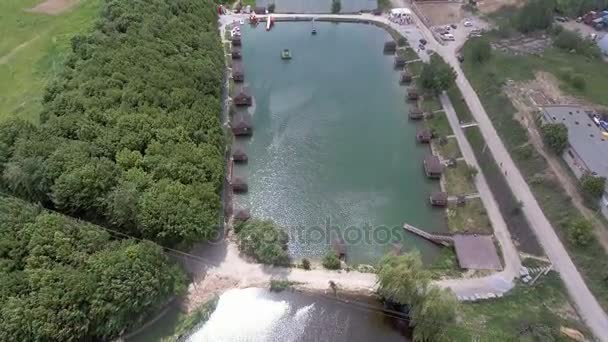 Widok z lotu ptaka na brzegu jeziora. Drewniane domy w pobliżu wody. — Wideo stockowe