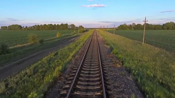 Imágenes aéreas de un avión no tripulado volando a lo largo de una vía de tren en una zona rural — Vídeo de stock