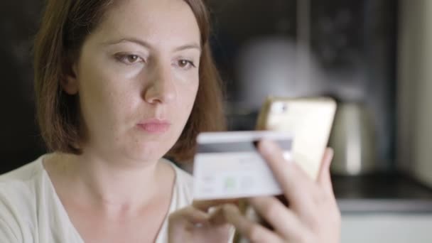 Meisje voert credit cardnummer op een smartphone — Stockvideo