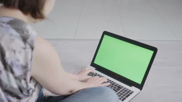 Молода жінка сидить біля ноутбука крупним планом — стокове відео