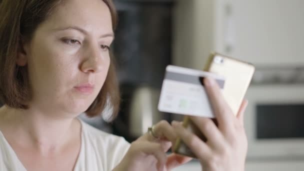 Κορίτσι μπαίνει αριθμό πιστωτικής κάρτας σε ένα smartphone — Αρχείο Βίντεο