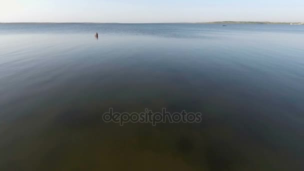 Вид с воздуха с летающего дрона человека рыбачит, в море — стоковое видео