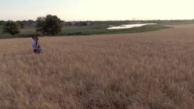 Yaz aylarında, kucak ve öpücük buğday alanında ayakta aşık güzel Çift