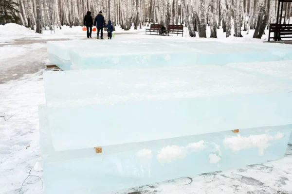 Лід розрізали на блоки для будівництва льодовикового міста. Льодові цеглини лежать на дерев'яних реквізитах . Ліцензійні Стокові Зображення