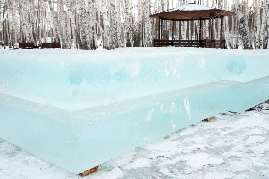 Ice cut into blocks. Ice bricks lie on wooden props. Build an ice town