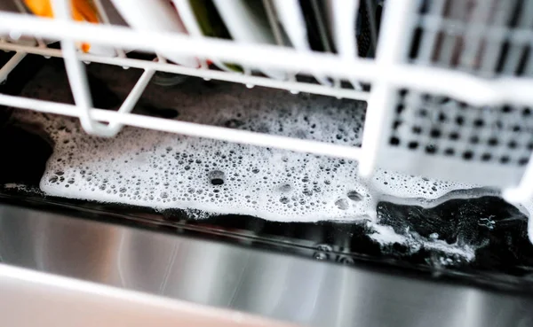 Избыточное моющее средство на дне посудомоечной машины после стирки. Пена — стоковое фото