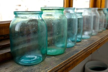 Konserveler için cam kavanozlar balkonda. Kirli hazırlıksız konserveler.