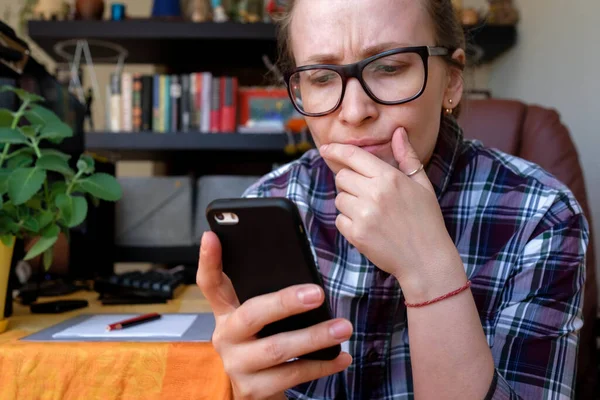 Дівчина бачить погані новини по телефону. Негативний онлайн. Чоловік захищає обличчя рукою в розбіжності Ліцензійні Стокові Зображення