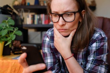 Freelancer evde çalışıyor. Telefondan haberleri okuyor..