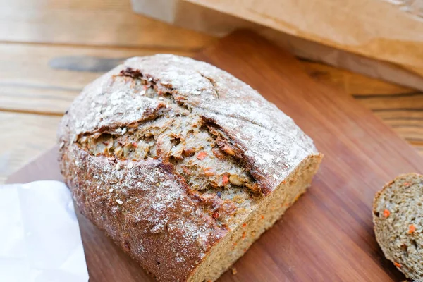 Хлеб, кусочек, бумажный пакет. Домашний хлеб с зерном и морковью — стоковое фото