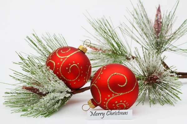 Joyeux Noël carte avec boules rouges et pin recouvert de flocons de neige — Photo