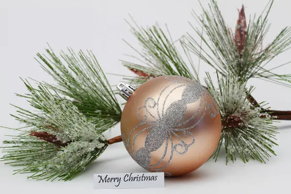 Feliz cartão de Natal com bauble cor creme e pinho coberto com flocos de neve — Fotografia de Stock
