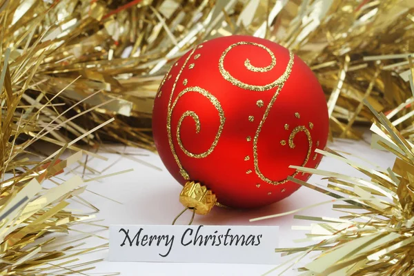 Merry Christmas card met rood bauble en mousserende gouden ketting — Stockfoto