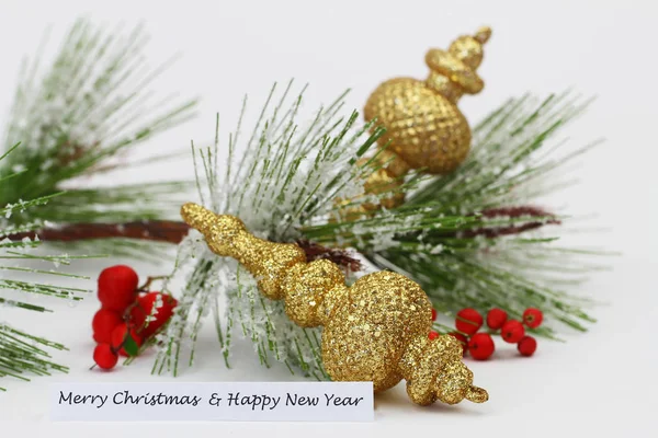 Feliz Navidad y Feliz Año Nuevo con bolas de oro y pino cubierto de nieve — Foto de Stock