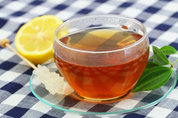 Tasse Tee, Zuckerstange und Zitrone — Stockfoto