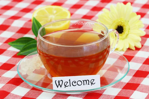 Welkomstkaart met kopje thee, citroen en gerbera daisy — Stockfoto