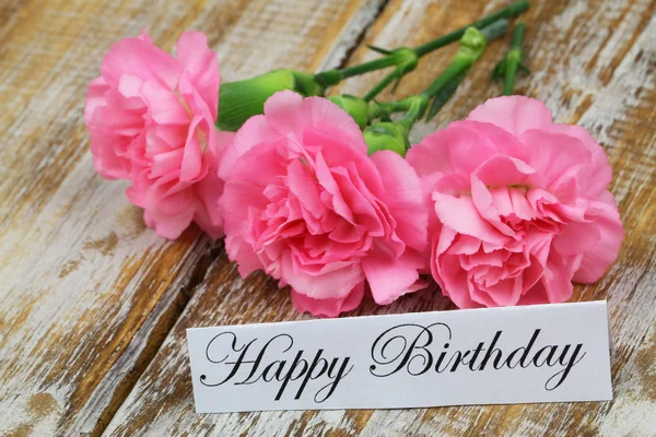 stock image Happy birthday card with pink carnations on rustic wooden surface