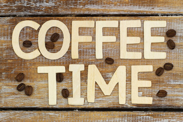 Coffee time written with wooden letters on rustic wooden surface