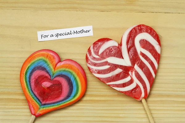 Κάρτα για τη γιορτή της μητέρας με δύο πολύχρωμα γλειφιτζούρια σε ξύλινη επιφάνεια — Φωτογραφία Αρχείου
