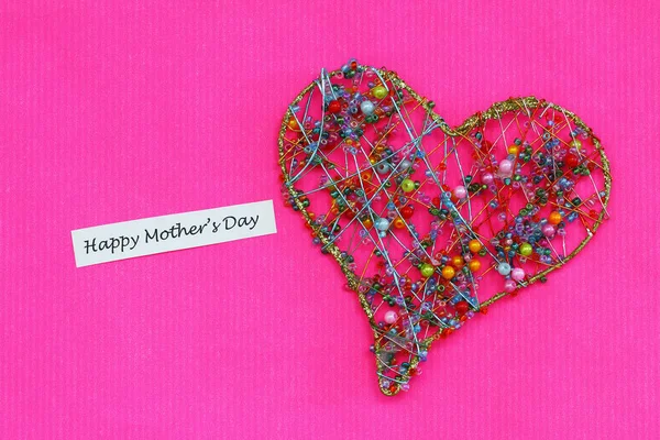 Happy Mother\'s day card with heart made of colorful beads on vivid pink background