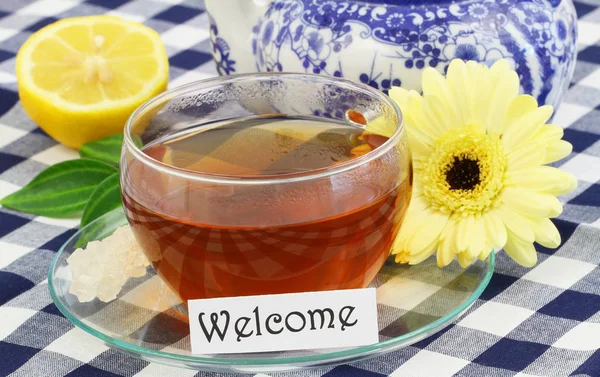 Cartão de boas-vindas com xícara de chá, limão e creme gerbera daisy — Fotografia de Stock