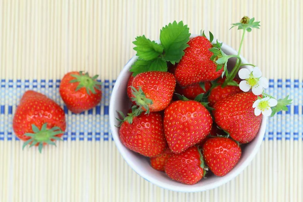 Schüssel mit frischen Erdbeeren auf Bambusmatte — Stockfoto