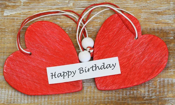 Cartão de aniversário feliz com dois corações de madeira vermelha — Fotografia de Stock